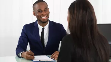 Person smiling during an office meeting.