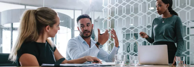 Three people having a meeting in a modern office.